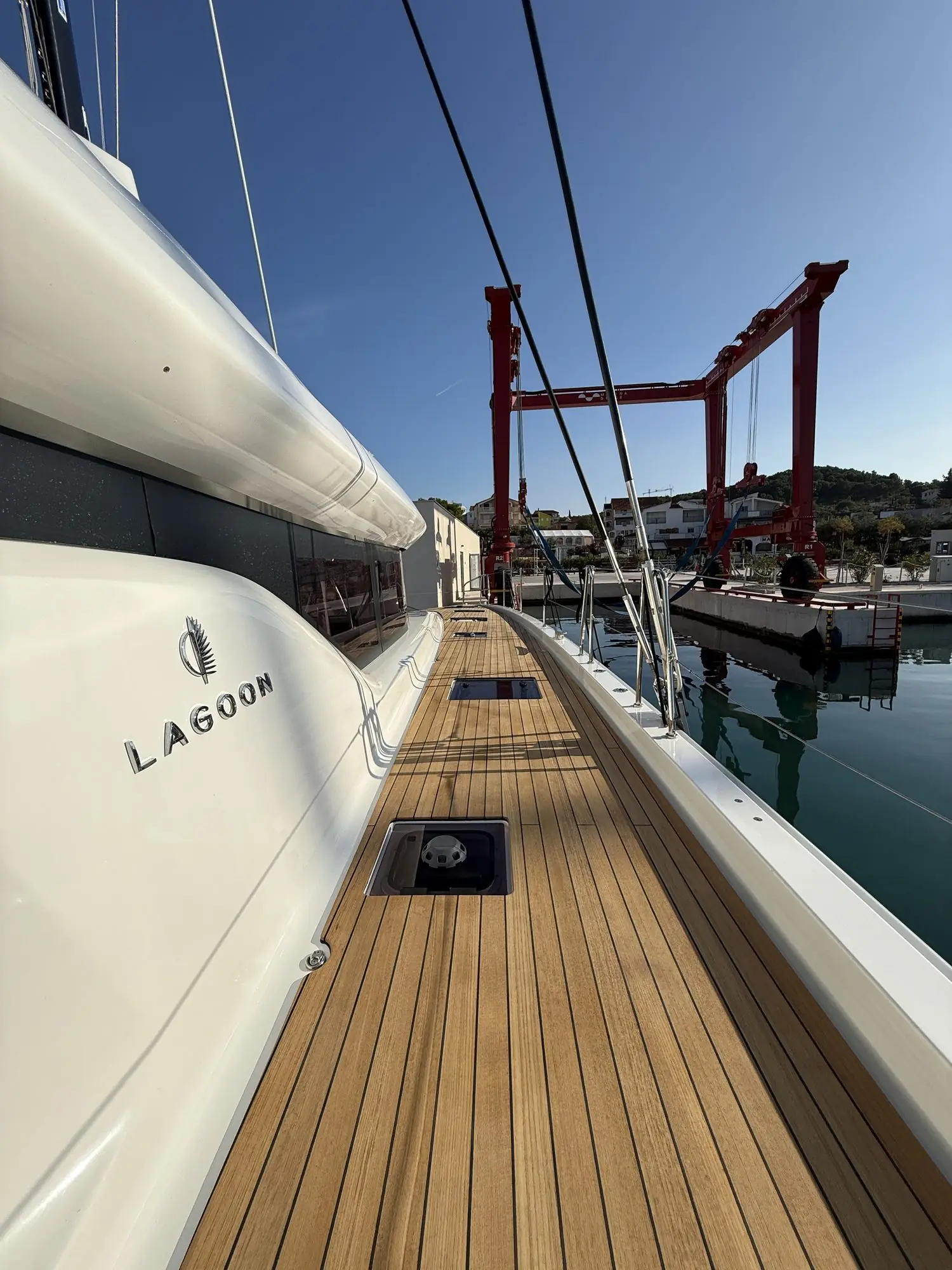 Charter catamaran side deck running to the bow, out of the water in the yard