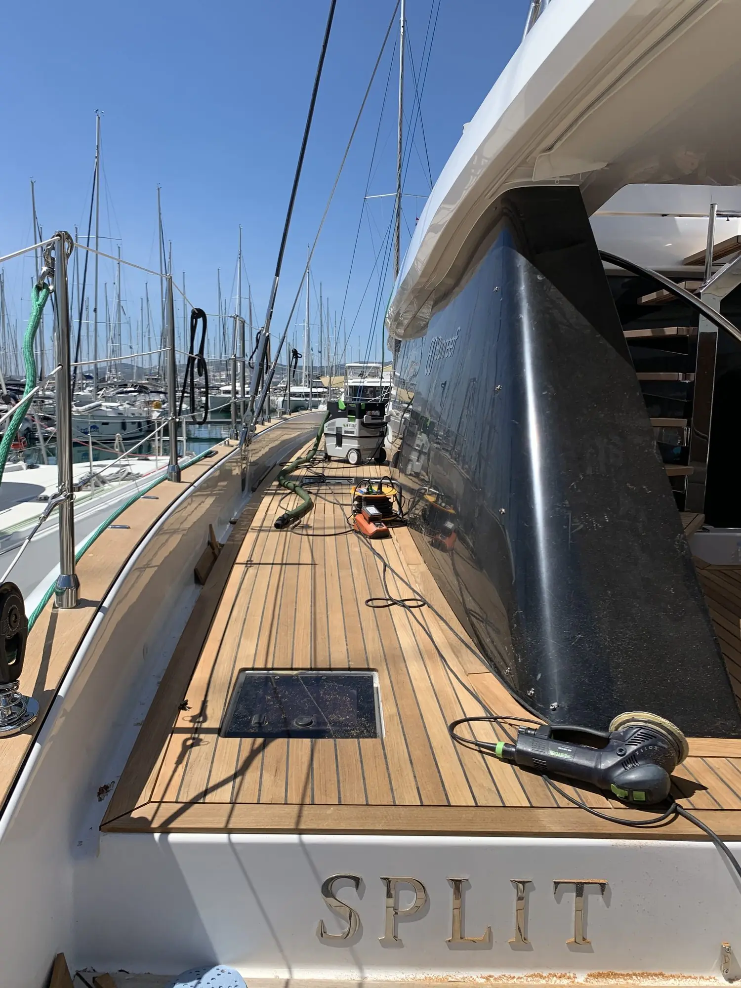 Sunreef 60 side deck during fitting, sander and extraction on the new teak