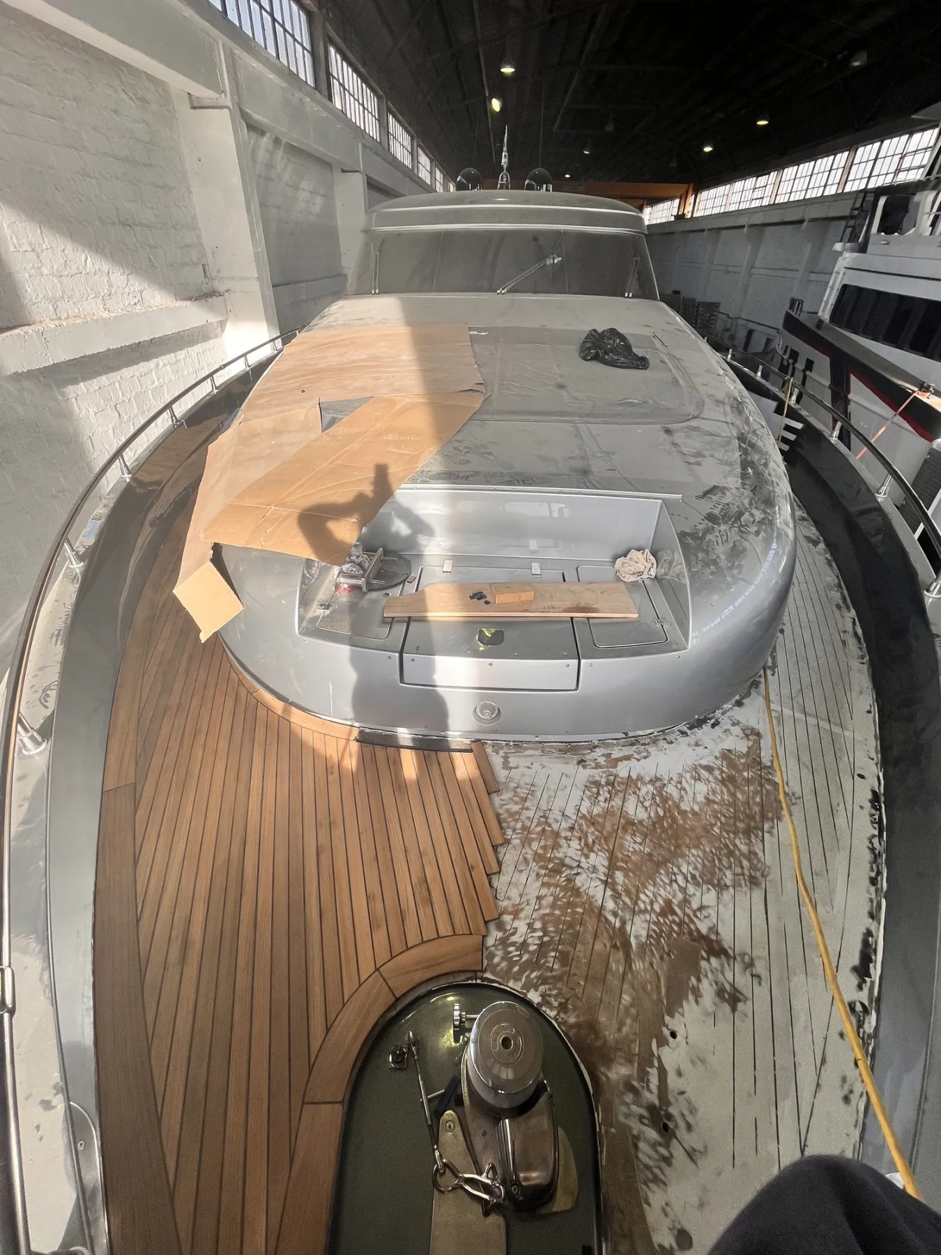 Foredeck half done: new teak panels beside the stripped old deck