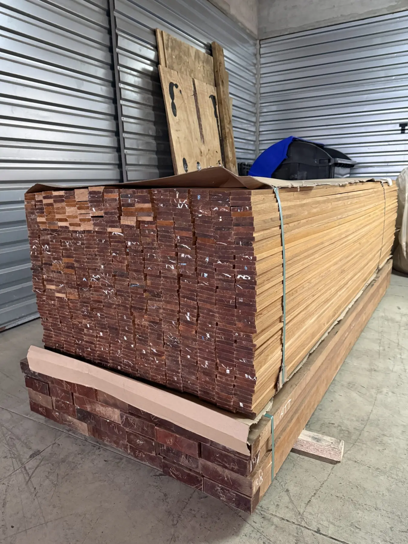 Stack of teak planks in stock in our workshop, banded and ready
